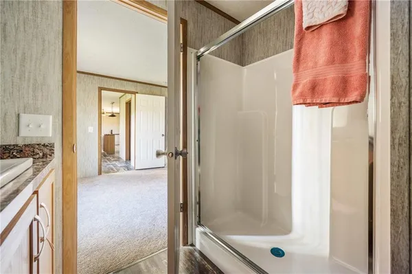 a bathroom with a granite countertop sink toilet and shower