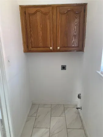 a view of a storage and utility room with wooden floor