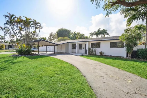 a view of house with a big yard and potted plants