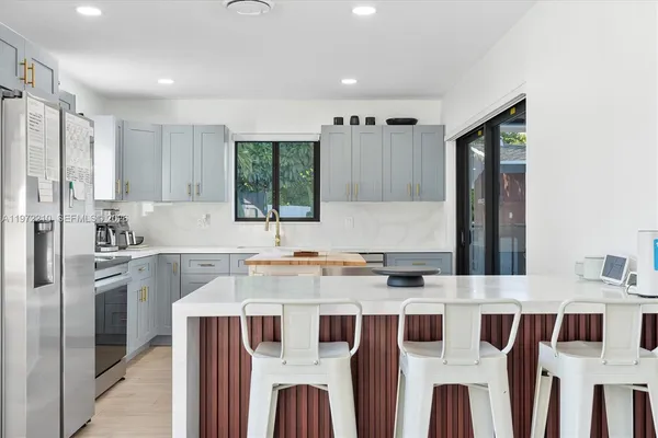 a kitchen that has a lot of cabinets in it and wooden floors