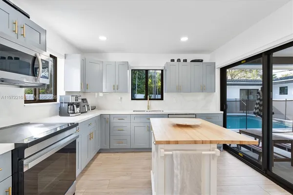 a kitchen with stainless steel appliances granite countertop a sink stove and cabinets