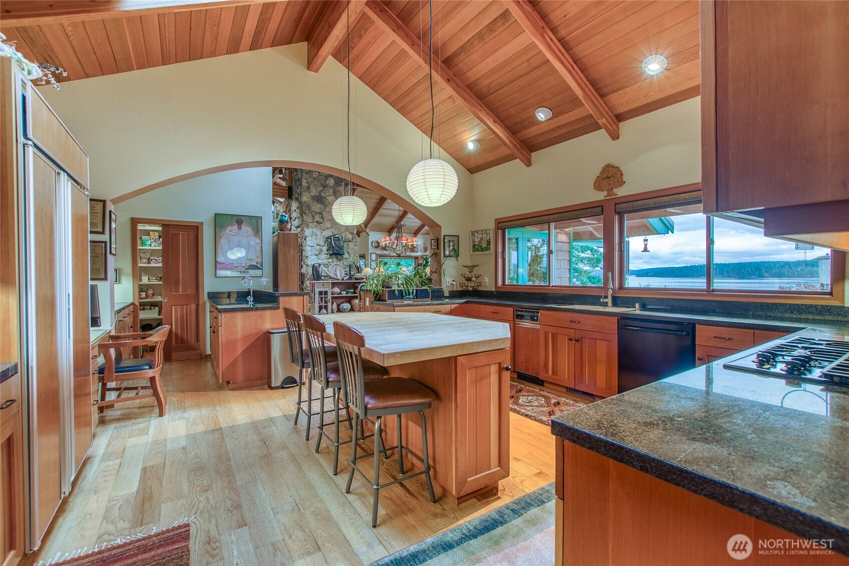 1689 Spring Point Road Orcas Island, WA 98245 - Photo 9 of 40 a kitchen with stainless steel appliances granite countertop a stove a sink dishwasher and a dining table with the view of living room