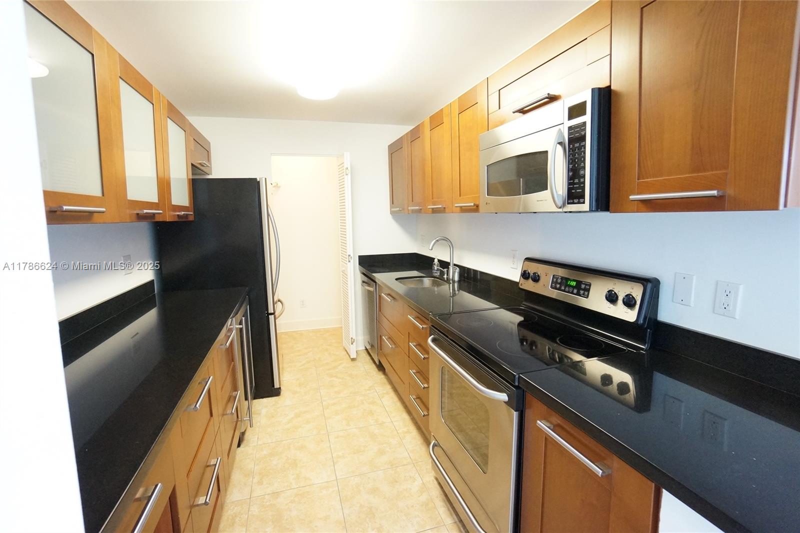 401 69th Street, Unit PH101 Miami Beach, FL 33141 - Photo 11 of 25 a kitchen with stainless steel appliances a refrigerator a stove and a sink