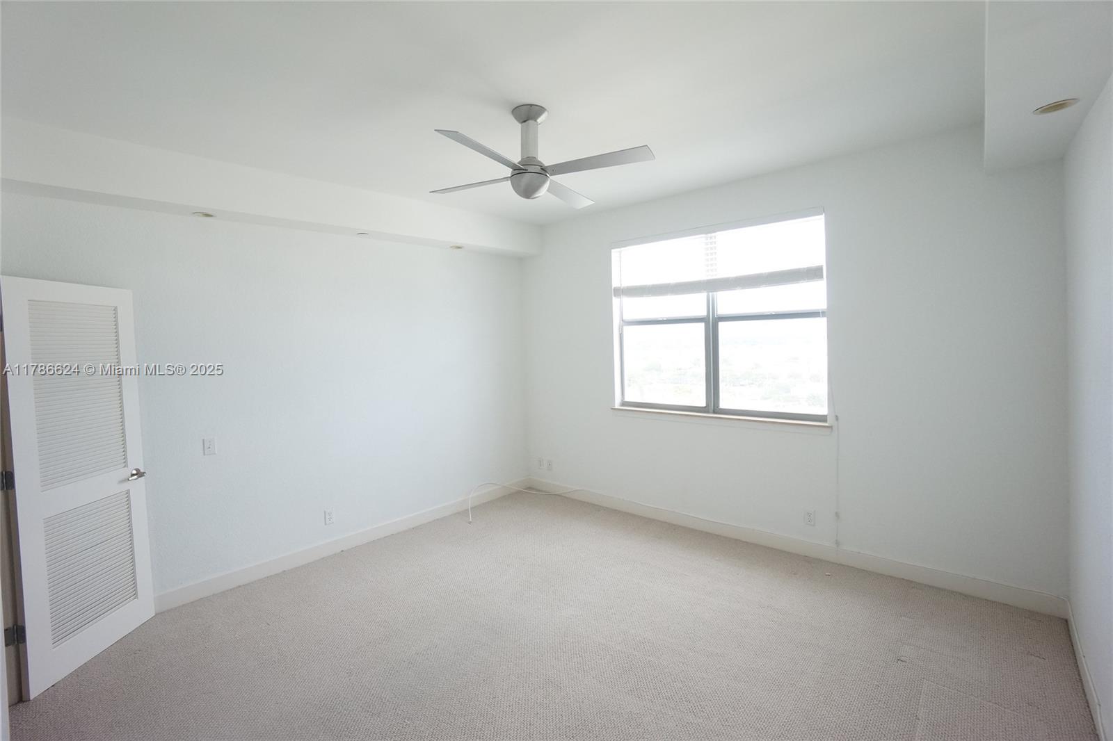 401 69th Street, Unit PH101 Miami Beach, FL 33141 - Photo 12 of 25 an empty room with a window and a fan