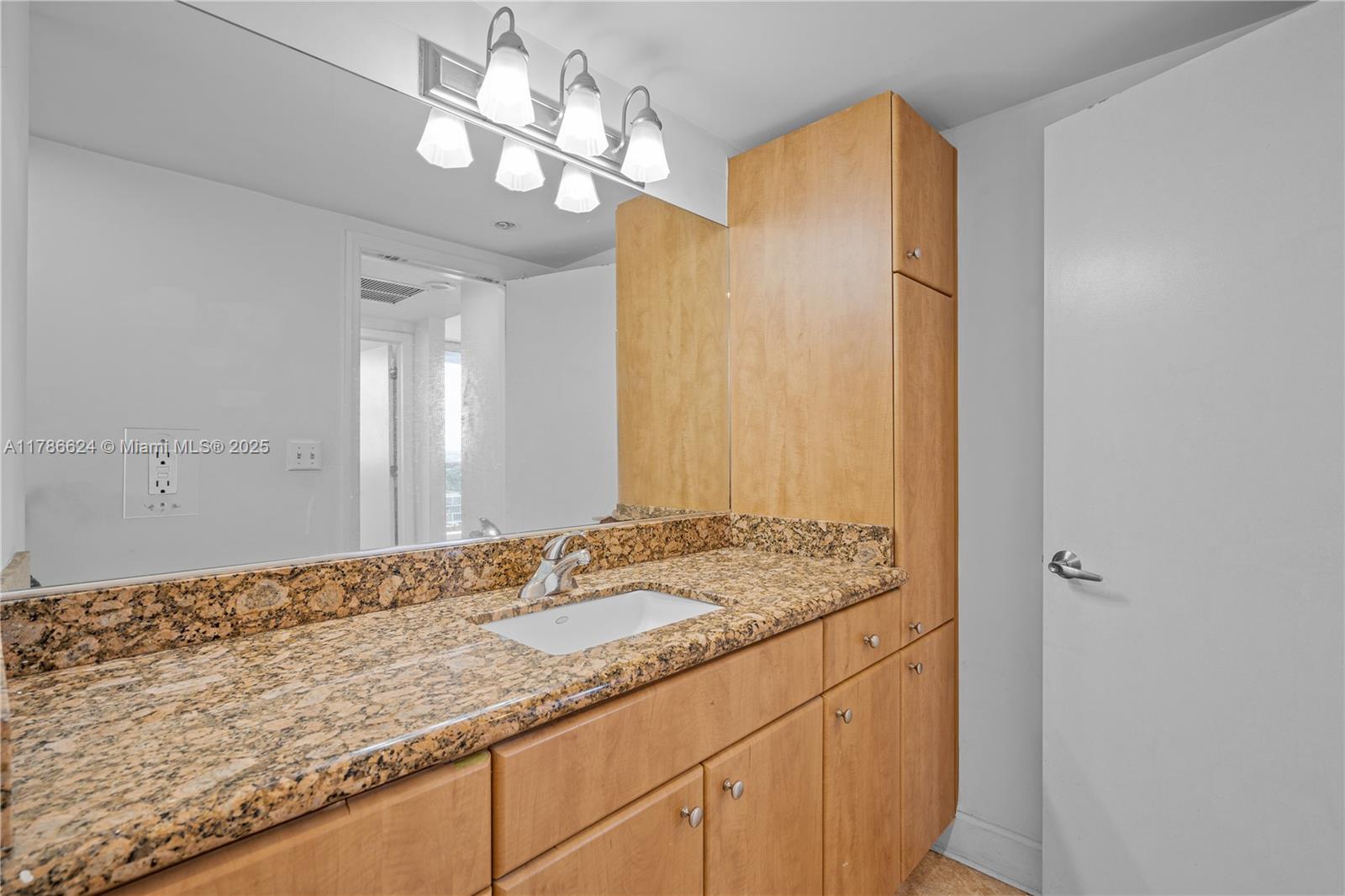 401 69th Street, Unit PH101 Miami Beach, FL 33141 - Photo 17 of 25 a bathroom with a granite countertop sink a mirror and a shower