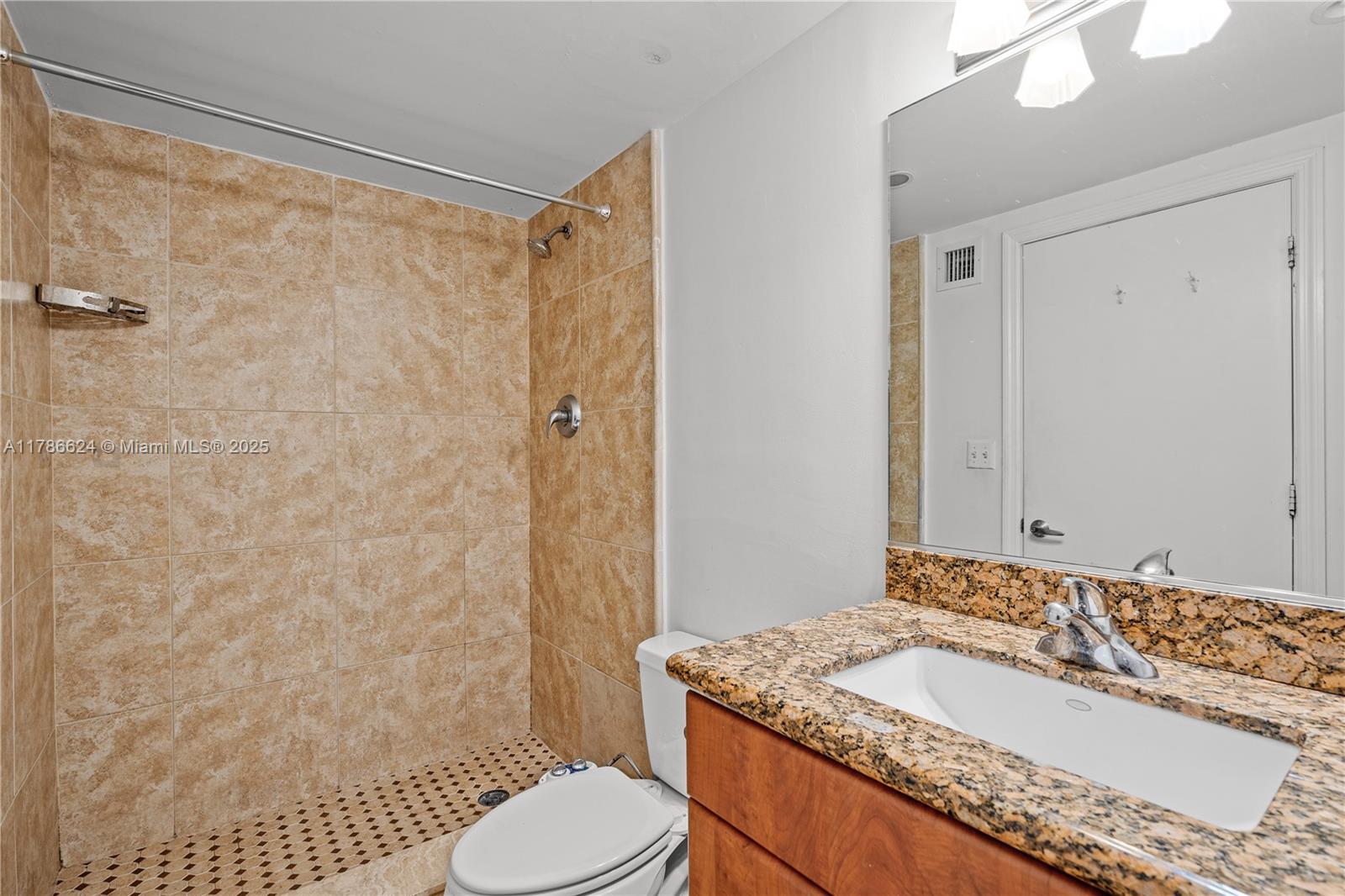 401 69th Street, Unit PH101 Miami Beach, FL 33141 - Photo 20 of 25 a bathroom with a granite countertop sink toilet and shower