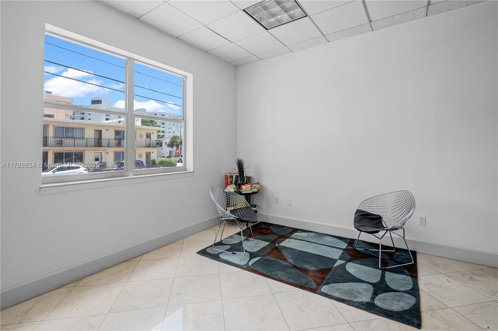 401 69th Street, Unit PH101 Miami Beach, FL 33141 - Photo 8 of 25 a living room with furniture and a window