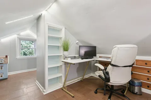 a view of a workspace with furniture and a window