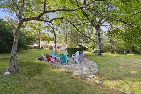 a view of a swimming pool with a patio and a yard