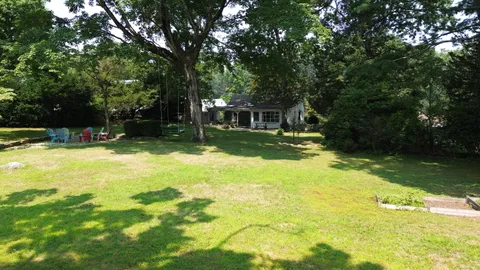 an aerial view of residential house with outdoor space and trees all around