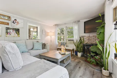 a living room with furniture a flat screen tv and a large window