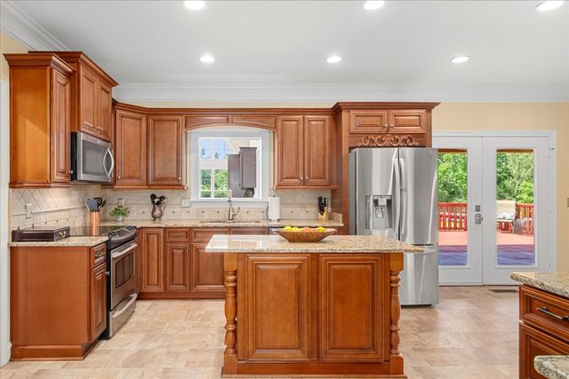 a spacious bedroom with a bed a couch and a chandelier