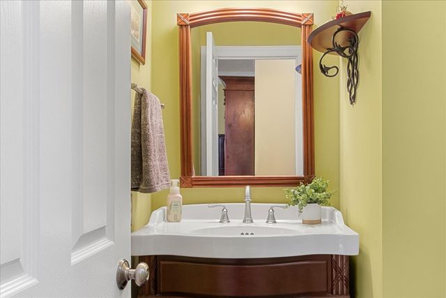 a yellow house with a big yard and large trees