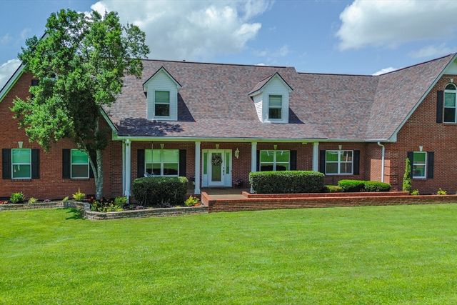 a front view of a brick house with a yard