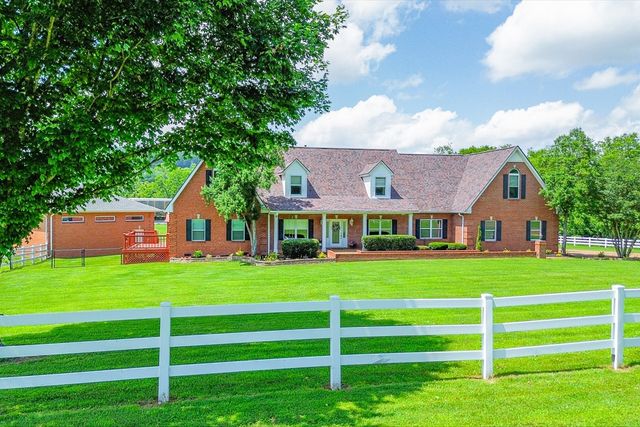 a front view of a house with a yard and trees