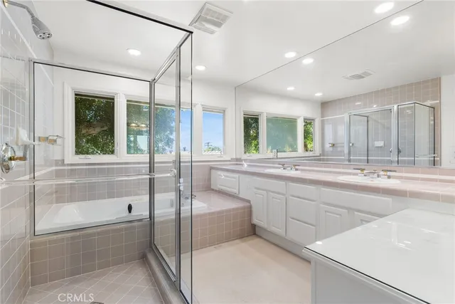 a bathroom with a tub a sink shower and mirror