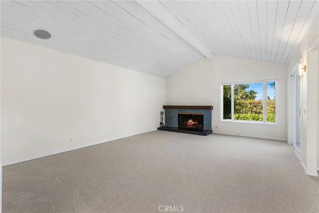 a view of an empty room with a fireplace and a window