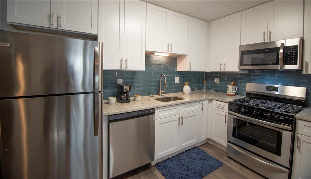 a kitchen with stainless steel appliances granite countertop a refrigerator stove and microwave