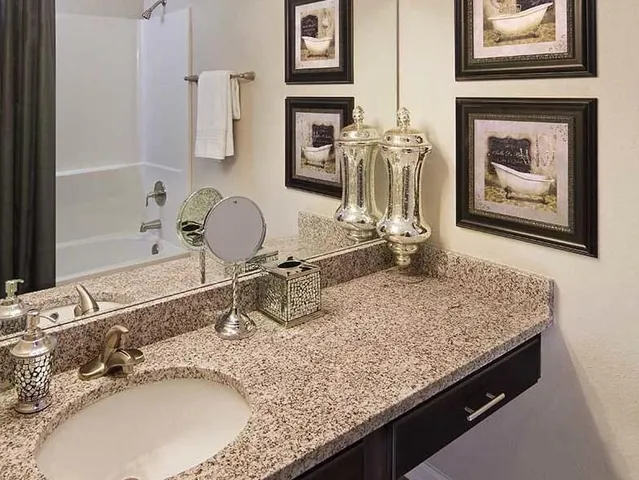a bathroom with a granite countertop sink and a mirror