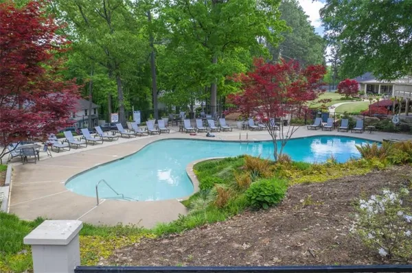 a view of a swimming pool with a lawn chairs under an umbrella