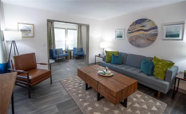 a living room with furniture a rug and a window