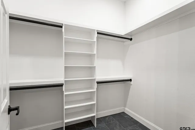 a view of walk in closet with empty racks