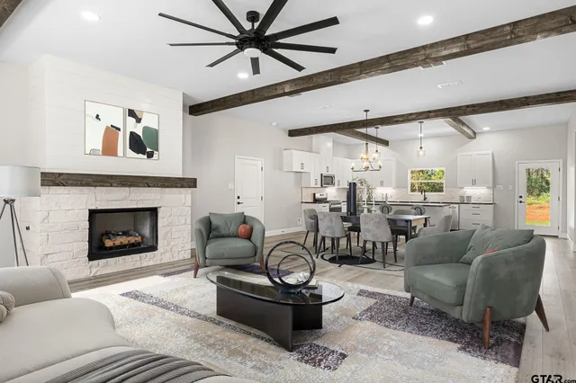 a living room with furniture a fireplace and a ceiling fan