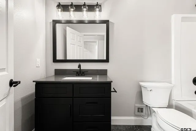 a bathroom with a toilet sink and mirror
