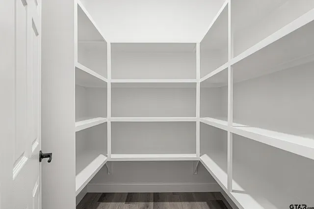 a view of walk in closet with empty racks