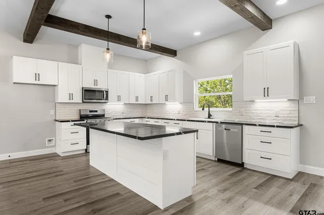 a kitchen with stainless steel appliances granite countertop a stove and white cabinets