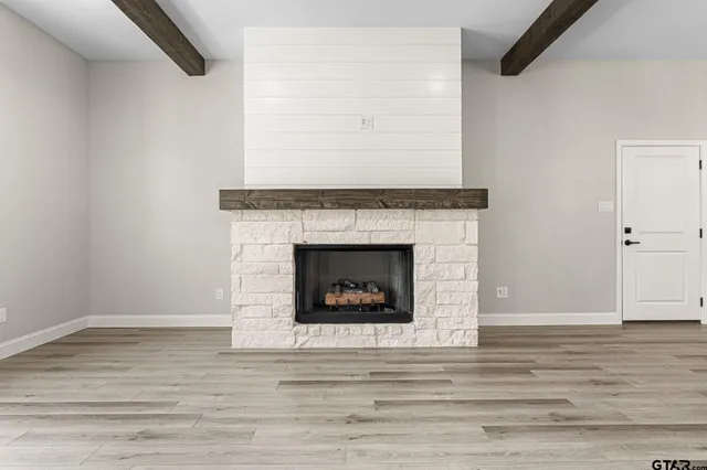 a living room with a fireplace and wooden floor