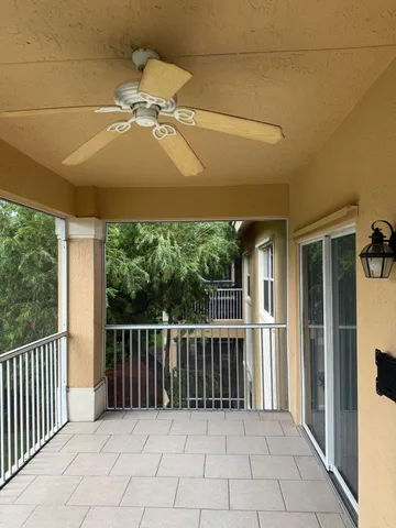an empty room with windows and ceiling fan