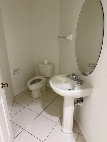a bathroom with a sink toilet and a mirror