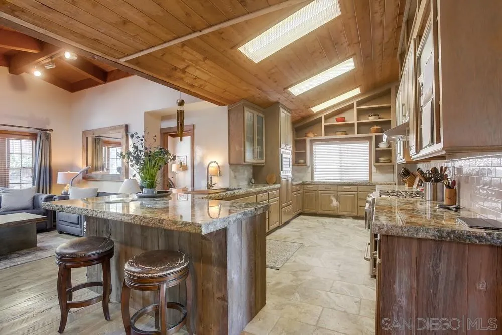 342 Cole Ranch Road Encinitas, CA 92024 - Photo 9 of 34 a kitchen with kitchen island granite countertop lots of counter top space and dining table