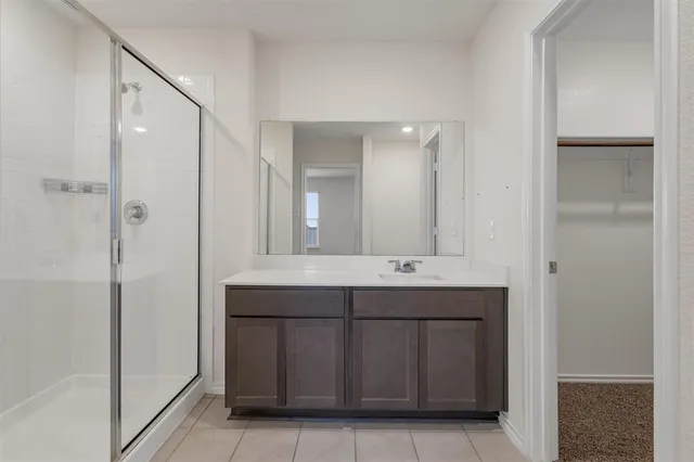 a spacious bathroom with a mirror sink and shower