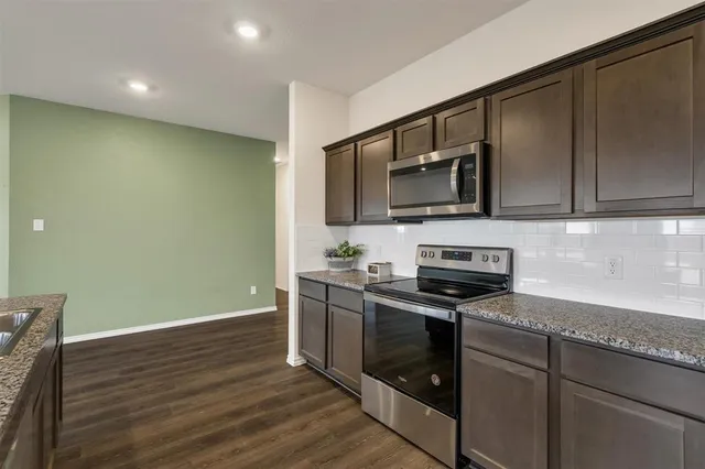a kitchen with stainless steel appliances wooden cabinets and a stove top oven