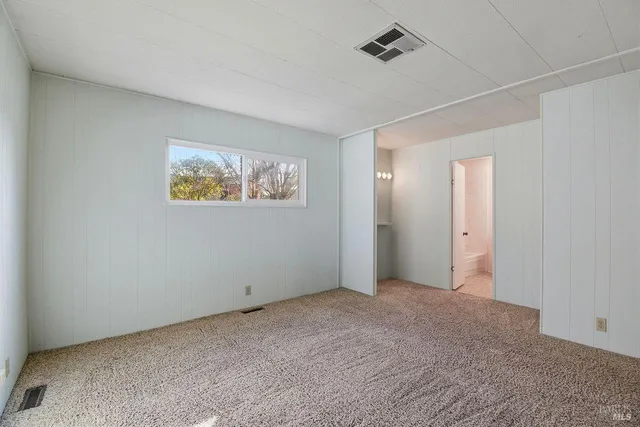an empty room with a painting and fan