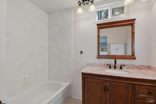 a bathroom with a bathtub sink and mirror