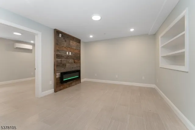 an empty room with a fireplace and cabinet