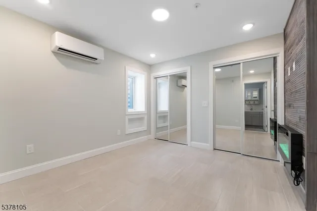 an empty room with glass door and chandelier fan