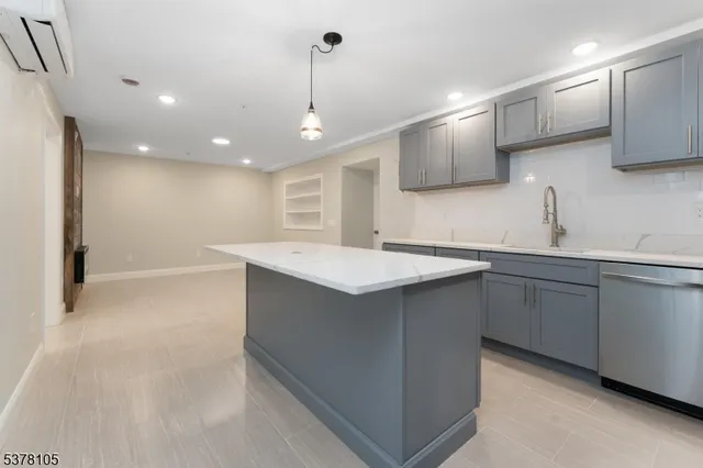 a kitchen with kitchen island a sink stainless steel appliances and cabinets