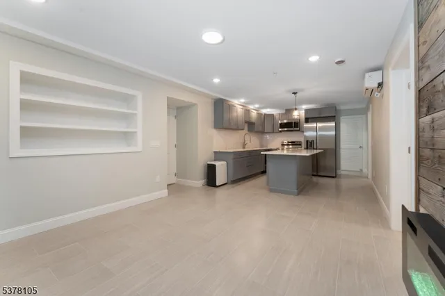 a kitchen with stainless steel appliances kitchen island a large counter top and a refrigerator