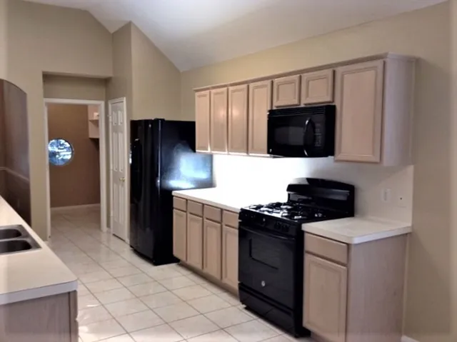 a kitchen with a refrigerator and a stove top oven
