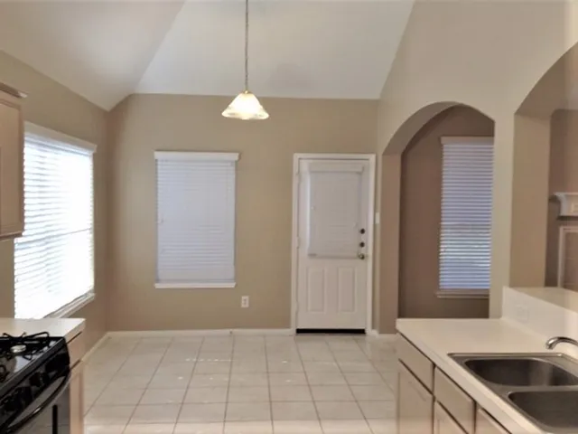 a kitchen with granite countertop a sink a stove and cabinets