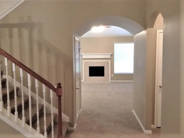 a view of a livingroom with wooden floor and staircase