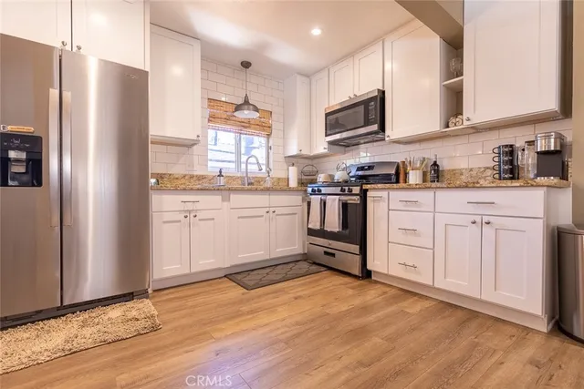 a kitchen with stainless steel appliances granite countertop a stove a sink and a refrigerator