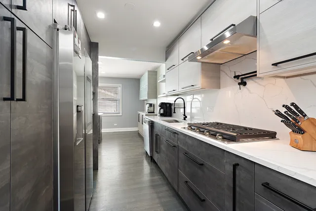 a kitchen with stainless steel appliances granite countertop a sink a stove and refrigerator