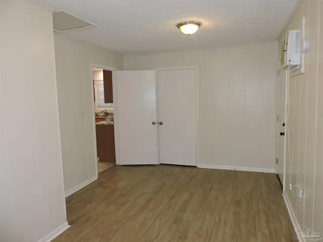 an empty room with wooden floor and white walls