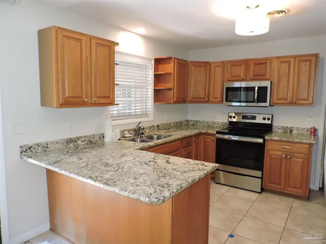 a kitchen with stainless steel appliances granite countertop a sink stove and microwave