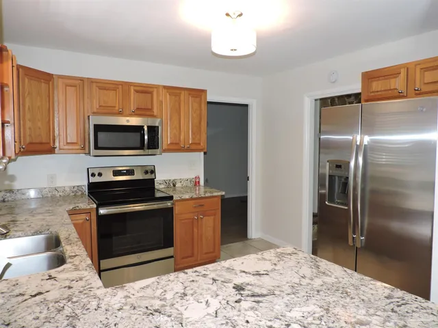 a kitchen with stainless steel appliances granite countertop a refrigerator stove and microwave